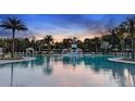 Resort-style pool featuring a water slide, lounging cabanas, palm trees, and ample deck space for relaxation at 8355 Velda Trl, Sarasota, FL 34241