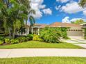 Charming home featuring lush landscaping, beautiful lawn, and a three-car garage at 8687 Woodbriar Dr, Sarasota, FL 34238