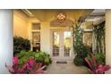 Inviting front entrance with double doors, decorative light fixture, and lush landscaping at 8687 Woodbriar Dr, Sarasota, FL 34238