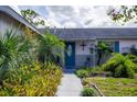 Inviting single-story home with landscaped yard, walkway and an attractive blue door at 1108 65Th W Ave, Bradenton, FL 34207