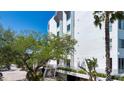 Exterior view of condominium building with lush landscaping, an inviting entrance with stairs and convenient parking at 1255 E Peppertree Dr # 506, Sarasota, FL 34242