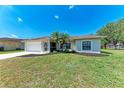 Inviting single-story home with a manicured front lawn and complemented by mature landscaping at 1323 Arredondo St, North Port, FL 34286