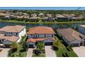 Beautiful lakefront property features a two-story home with a red tile roof, mature landscaping, and a two-car garage at 13409 Ramblewood Trl, Bradenton, FL 34211