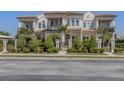 Elegant multi-story home with manicured landscaping, iron gate, and private balconies on a sunny day at 212 Milan W Ave # 1, Venice, FL 34285