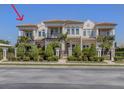 Elegant multi-story home with manicured landscaping, iron gate, and private balconies on a sunny day at 212 Milan W Ave # 1, Venice, FL 34285
