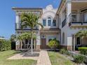 Beautiful home with a front walkway, balcony, palm trees and manicured lawn at 212 Milan W Ave # 1, Venice, FL 34285