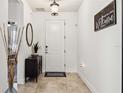 Bright foyer featuring neutral tile, a welcome sign, and a view to the rest of the home at 2177 Weaver Bird Ln, Venice, FL 34292