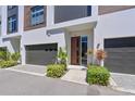 Modern townhome exterior showing contemporary design, private garage, and welcoming landscaping at 221 Cosmopolitan Ct, Sarasota, FL 34236