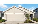 View of the garage featuring neutral siding, white trim, and a welcoming front entrance at 2812 Rock Sound St, Bradenton, FL 34208