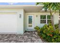 Inviting single-story home features a well-maintained lawn, plants and a brick driveway leading to an attached garage at 2840 S Shade Ave, Sarasota, FL 34239