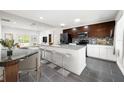Modern kitchen with granite countertops, stainless steel appliances, and a breakfast bar overlooking the living area at 2840 S Shade Ave, Sarasota, FL 34239