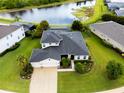 Aerial view of home with a screened pool, lush green landscaping, a long driveway, and a lovely pond at 2918 130Th E Ave, Parrish, FL 34219