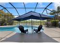 Beautiful pool with sun shelf, umbrella, outdoor seating, and lovely views of the water at 2918 130Th E Ave, Parrish, FL 34219