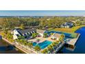 Aerial view of community pool, tennis courts, and clubhouse surrounded by manicured landscaping and waterfront views at 304 108Th W St, Bradenton, FL 34209
