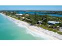 Gorgeous aerial view of beachfront property with pristine white sand and turquoise water at 3201 Casey Key Rd, Nokomis, FL 34275