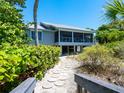 Charming beach house with a private walkway, mature trees, and serene surroundings at 3201 Casey Key Rd, Nokomis, FL 34275