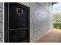 Condo entrance featuring a black door with a decorative wreath and textured stucco wall at 3251 Beneva Rd # 104, Sarasota, FL 34232