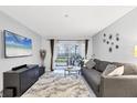 Cozy living room with plush rug, gray sofa, modern decor, and patio access through sliding glass doors at 3251 Beneva Rd # 104, Sarasota, FL 34232