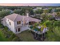 Back exterior aerial view showcasing a private backyard with a pool, lush landscaping, and a covered patio at 3432 Founders Club Dr, Sarasota, FL 34240