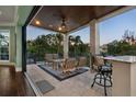 Cozy outdoor seating on a covered balcony with a wet bar and views of the lush tropical surroundings at 3465 Gulfmead Dr, Sarasota, FL 34242