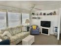 Cozy living room with comfortable seating, shelving, and a decorative fireplace at 3710 Gulf Of Mexico Dr # A20, Longboat Key, FL 34228