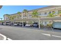 Well-maintained carport with ample parking, complemented by lush palm trees and exterior condo architecture at 4380 Exeter Dr # H202, Longboat Key, FL 34228