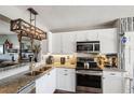 Modern kitchen featuring stainless steel appliances, granite counters, and stylish light fixture at 4410 Fairways Blvd # 605, Bradenton, FL 34209