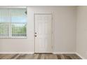 Entryway with wood-style laminate flooring, neutral paint, and a storm door with a large window at 4885 1St Ne St # 308, St Petersburg, FL 33703