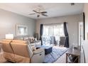 Cozy living room featuring a comfortable sofa, ceiling fan, rug, and sliding glass doors to the patio at 6334 Grand Oak Cir # 202, Bradenton, FL 34203