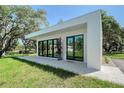 Modern exterior boasts black-framed windows, a stone patio, and lush landscaping at 7200 Chameleon Way, Sarasota, FL 34241