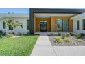 Modern home featuring clean lines, wood accents, lush landscaping and a contemporary front door at 7200 Chameleon Way, Sarasota, FL 34241
