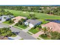 Beautiful neighborhood homes bordering a lush golf course and tranquil pond in this stunning aerial view at 8718 Grey Oaks Ave, Sarasota, FL 34238