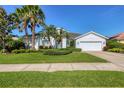 Charming one-story home with mature palm trees and a well-manicured lawn at 8718 Grey Oaks Ave, Sarasota, FL 34238