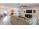 Bright living room with tiled floors, a ceiling fan, and an open floor plan connecting to the kitchen and dining area at 95 S Briggs Ave, Sarasota, FL 34237