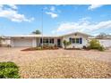 Charming single-story home with a brick driveway, blue shutters and a well manicured front yard at 10308 Kingfisher W Rd, Bradenton, FL 34209