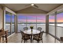 Enclosed lanai with sunset views, tile flooring, and a round table perfect for enjoying waterfront scenery at 1280 Dolphin Bay Way # 503, Sarasota, FL 34242