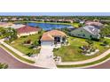 Aerial view of a lakeside community featuring a single-story home with mature landscaping and lush green lawns at 12830 24Th Street E Cir, Parrish, FL 34219