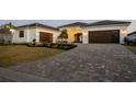 Attractive brick driveway leads to a modern three-car garage, enhanced by well-kept landscaping at 1613 4Th E St, Palmetto, FL 34221