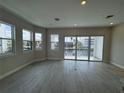 Bright living room with wood floors, large windows offering picturesque views, and access to a balcony at 1617 Sea Haven Dr # 501, Punta Gorda, FL 33950