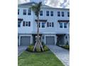 Close up view of an attractive condominium exterior with gray siding, trim, shutters, and a palm tree in the yard at 1617 Sea Haven Dr # 502, Punta Gorda, FL 33950
