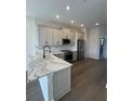 Modern kitchen with gray cabinets, granite countertops, stainless steel appliances, and wood floors at 1617 Sea Haven Dr # 502, Punta Gorda, FL 33950