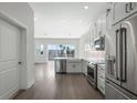 Clean kitchen with stainless steel appliances, white cabinets, marble countertops and hardwood floors leading to a living area at 1617 Sea Haven Dr # 502, Punta Gorda, FL 33950