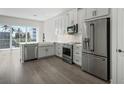 Modern, newly remodeled kitchen with stainless steel appliances, white cabinets, marble countertops, and hardwood floors at 1617 Sea Haven Dr # 502, Punta Gorda, FL 33950