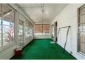 Inviting sunroom with green carpet, wood-paneled walls and ceiling fan at 1704 4Th W St, Palmetto, FL 34221
