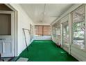 Enclosed porch with green carpet, white walls, and lots of windows at 1704 4Th W St, Palmetto, FL 34221