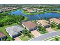 Aerial view showcasing a beautiful single-Gathering home near a scenic lake and lush green surroundings at 17820 Waterville Pl, Lakewood Ranch, FL 34202
