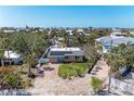 Aerial view of home with solar panels nestled among lush landscaping and neighboring properties near the coast at 216 Archer Way, Anna Maria, FL 34216