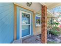 Inviting entryway with a blue-painted doorframe, brick column, and quaint curb appeal at 216 Archer Way, Anna Maria, FL 34216