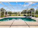 Screened-in pool featuring an attached spa, brick pavers, and outdoor kitchen with grill, sink, and storage at 244 Dove Trl, Bradenton, FL 34212