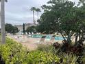 Community pool with surrounding lounge chairs, tables and mature landscaping at 3938 Yellowstone Cir, Sarasota, FL 34233